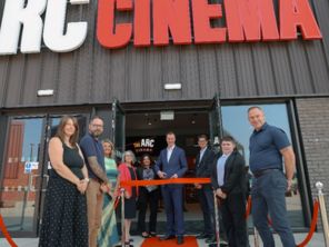 People stood outside the entrance of Arc Cinema with Leader of Rotherham Council cutting a red ribbon