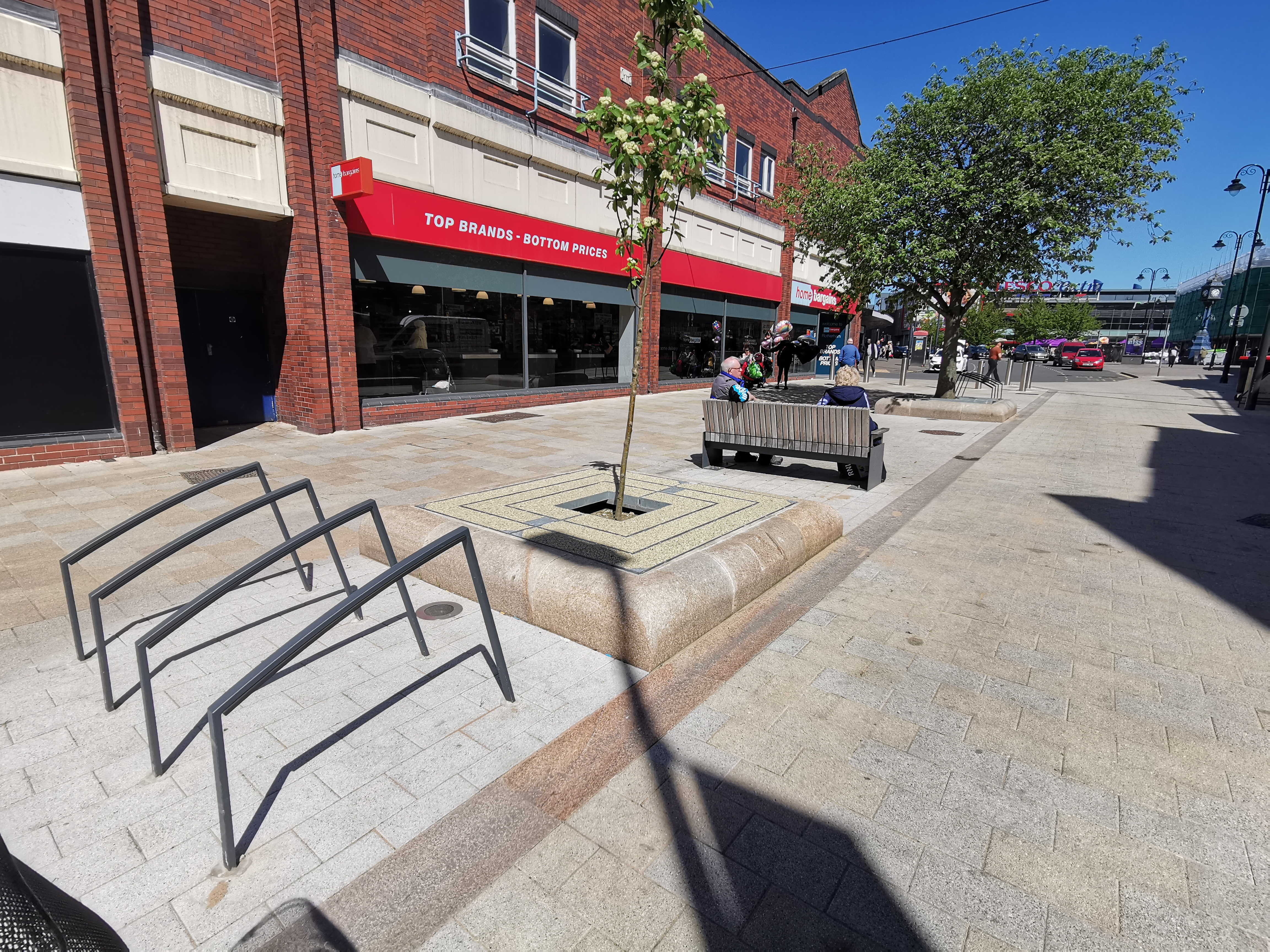 Fredrick Street in Rotherham.  Shop in the background. People sat on benches.