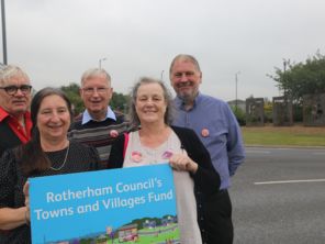 People stood to the left side holding a sign that reads "Rotherham Council Towns and Villages Fund".