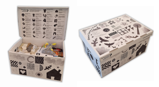 Photo of a baby pack box open and closed. The box features black illustrations all over, with an itemised list on the inside list. Example items can be seen inside the box.